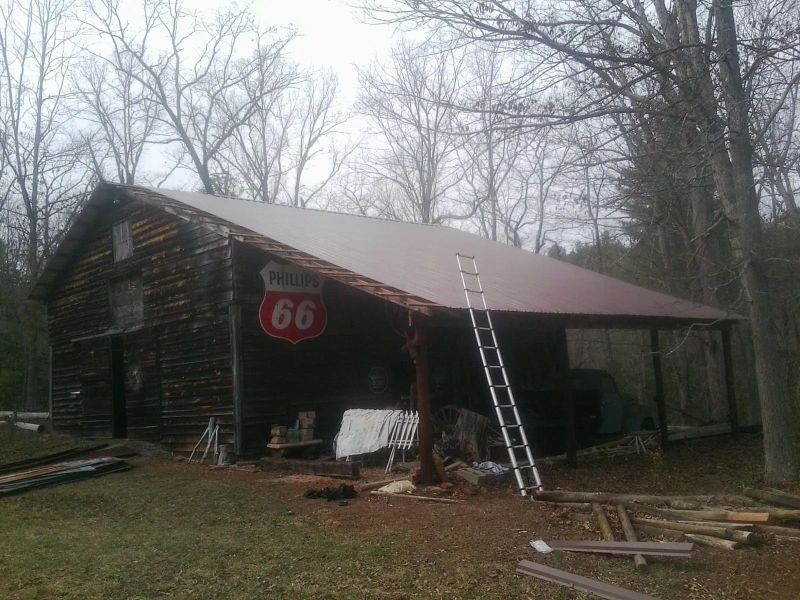 New metal roof on an open sided timber barn with a vintage sign in North Richland Hills