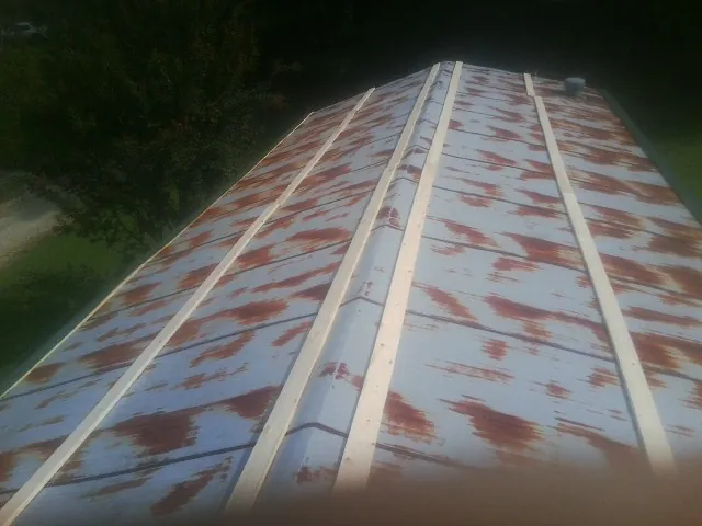 Rusted metal roof panels with new wood purlins before replacement — Storm Damage Roof Repair in North Richland Hills by Roofing Brothers